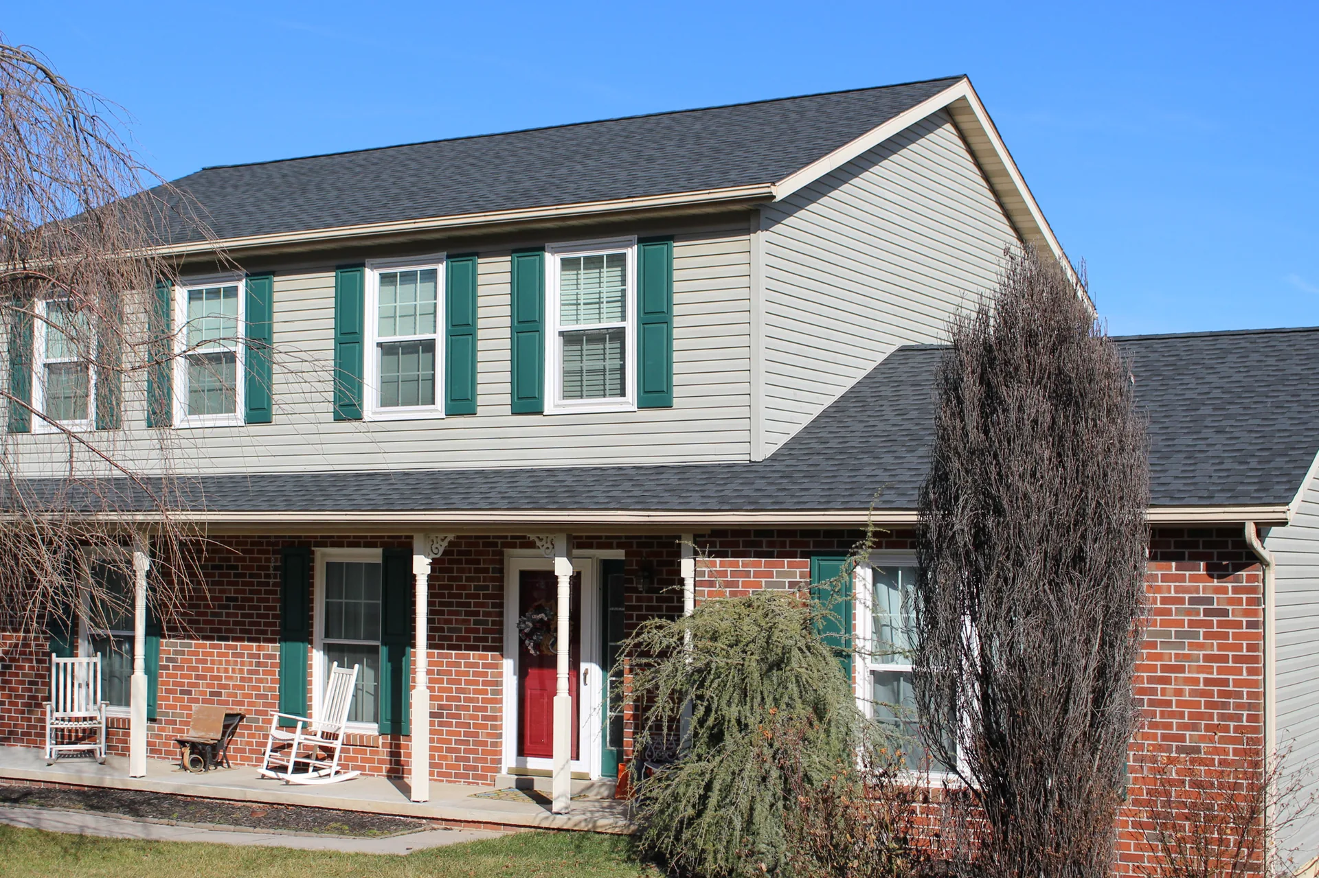Completed roof on a two-story colonial with green shutters in York County, PA by Cool Water Roofing